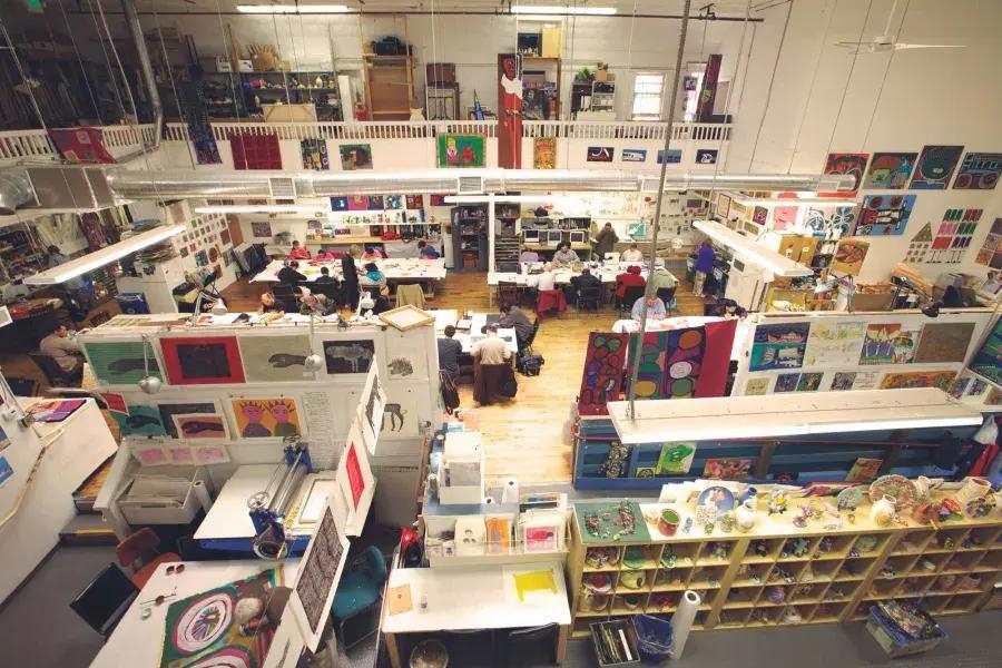 The floor of 创新探索, with an assortment of desks and works of art, seen from overhead.